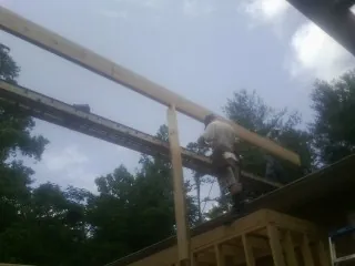 Carpenter setting a ridge beam over a new addition frame — Ice Dam Removal by Roofing Brothers in Mankato