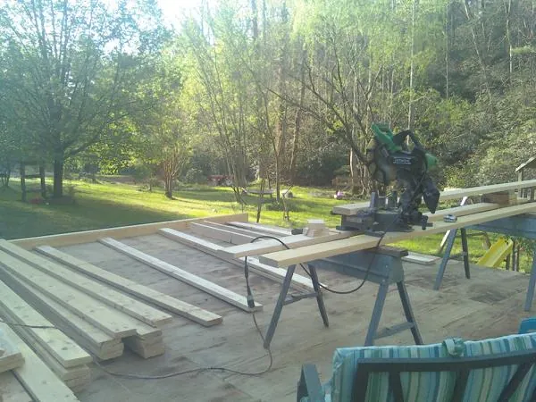 Miter saw and framing lumber on a deck under construction in Mankato