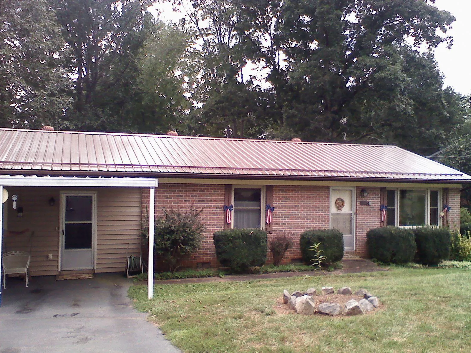 Bronze metal roof and carport on a brick ranch home — Roof Repair work by our crew in Mankato
