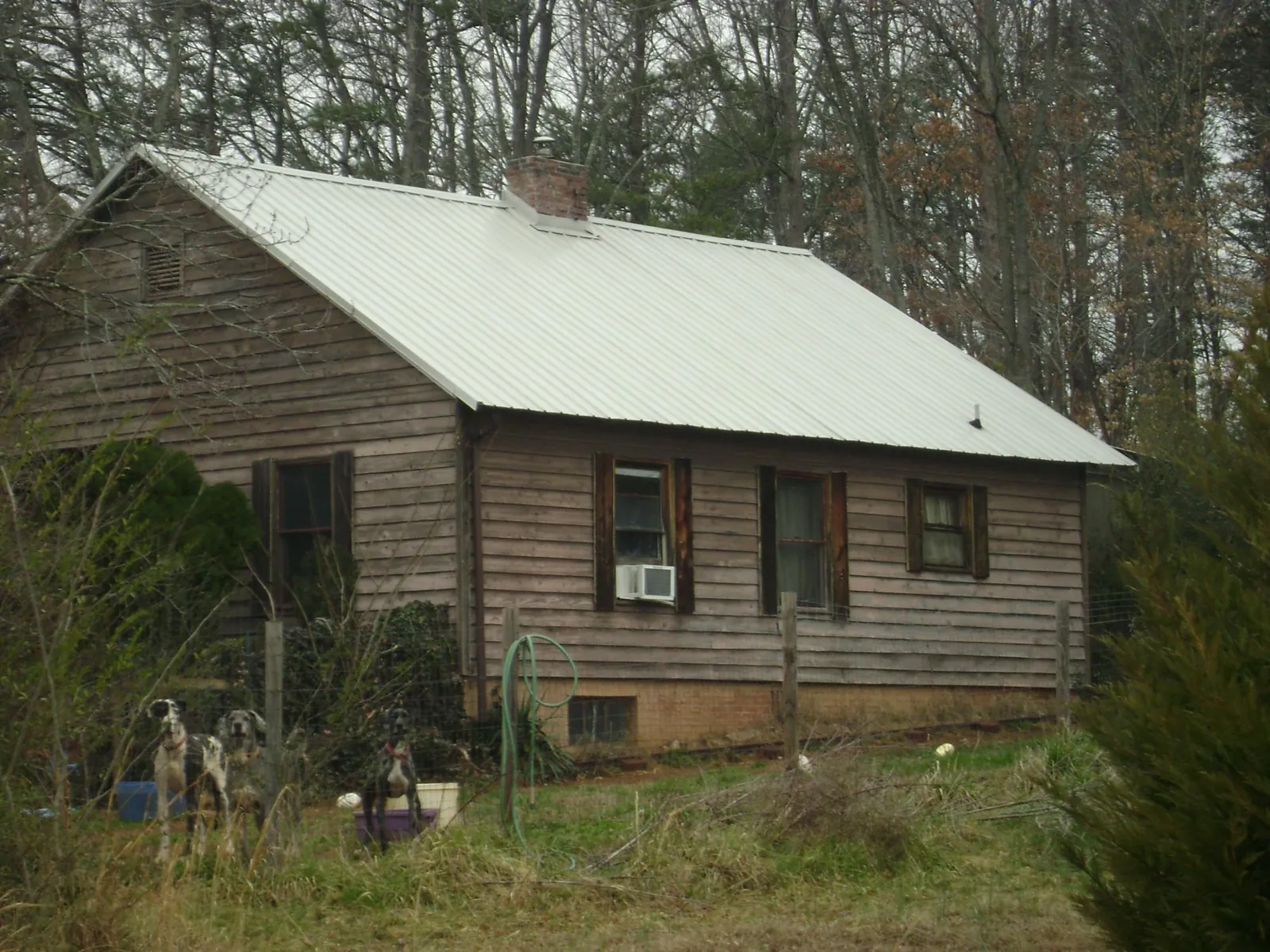 White metal roof on an old wood sided farmhouse, from a Asphalt Shingle Roof Repair job in Mankato
